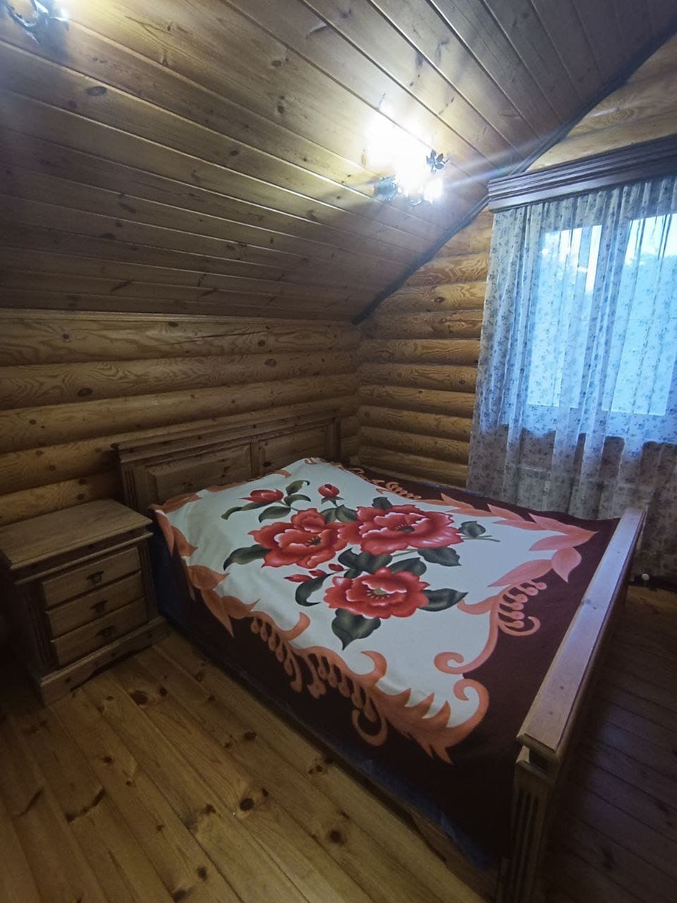 Спальня с двуспальной кроватью в бревенчатом доме